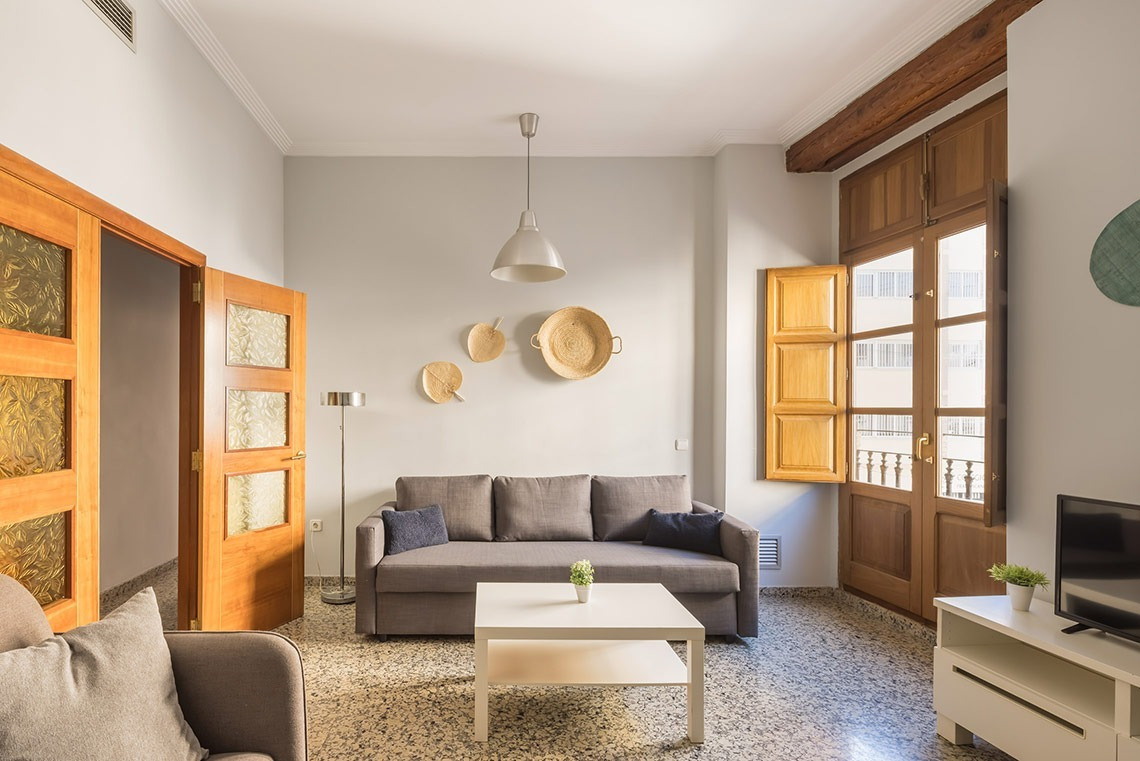 Sofá cama gris y mesa de centro en salón de Macflats Apartamento Puerto | Macflats Valencia | Web oficial.