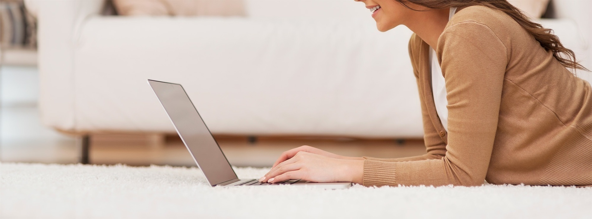 una mujer está escribiendo en un teclado de computadora portátil