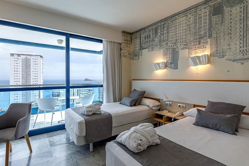 una habitación de hotel con dos camas y una gran ventana