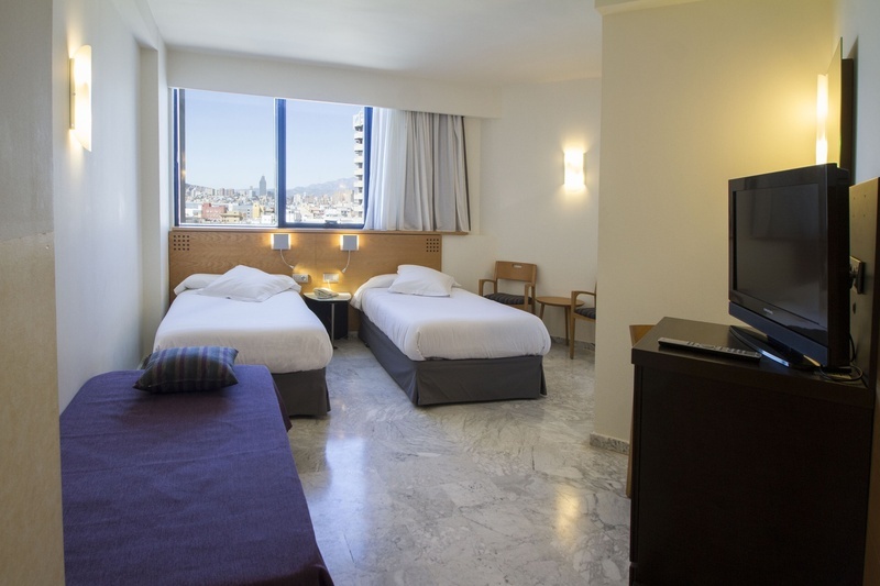 una habitación de hotel con dos camas y una televisión