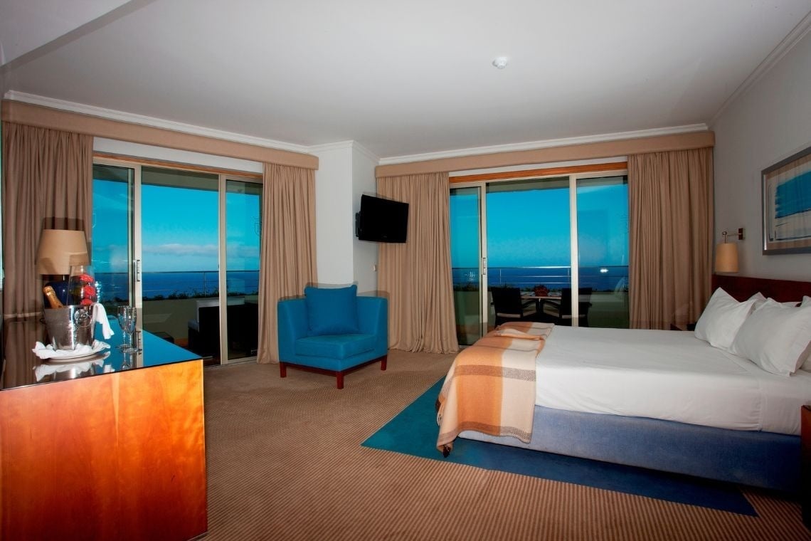 um quarto de hotel com cama , cadeira e televisão