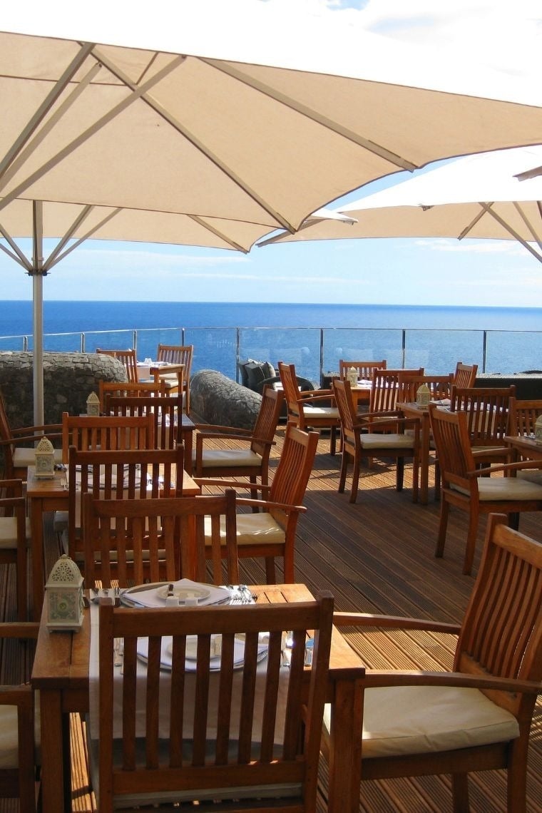 mesas e cadeiras em um restaurante com vista para o oceano