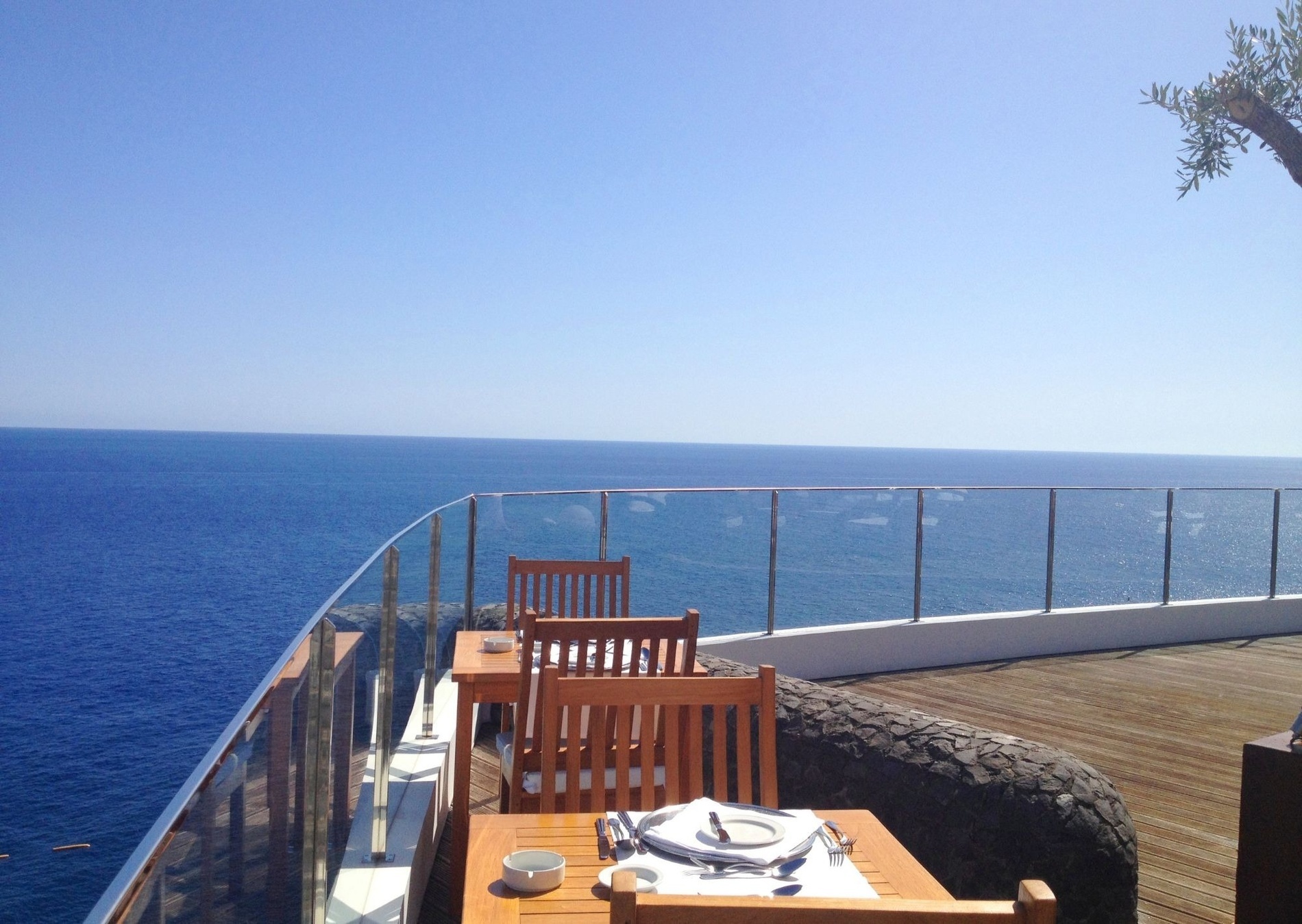 a table and chairs on a balcony overlooking the ocean