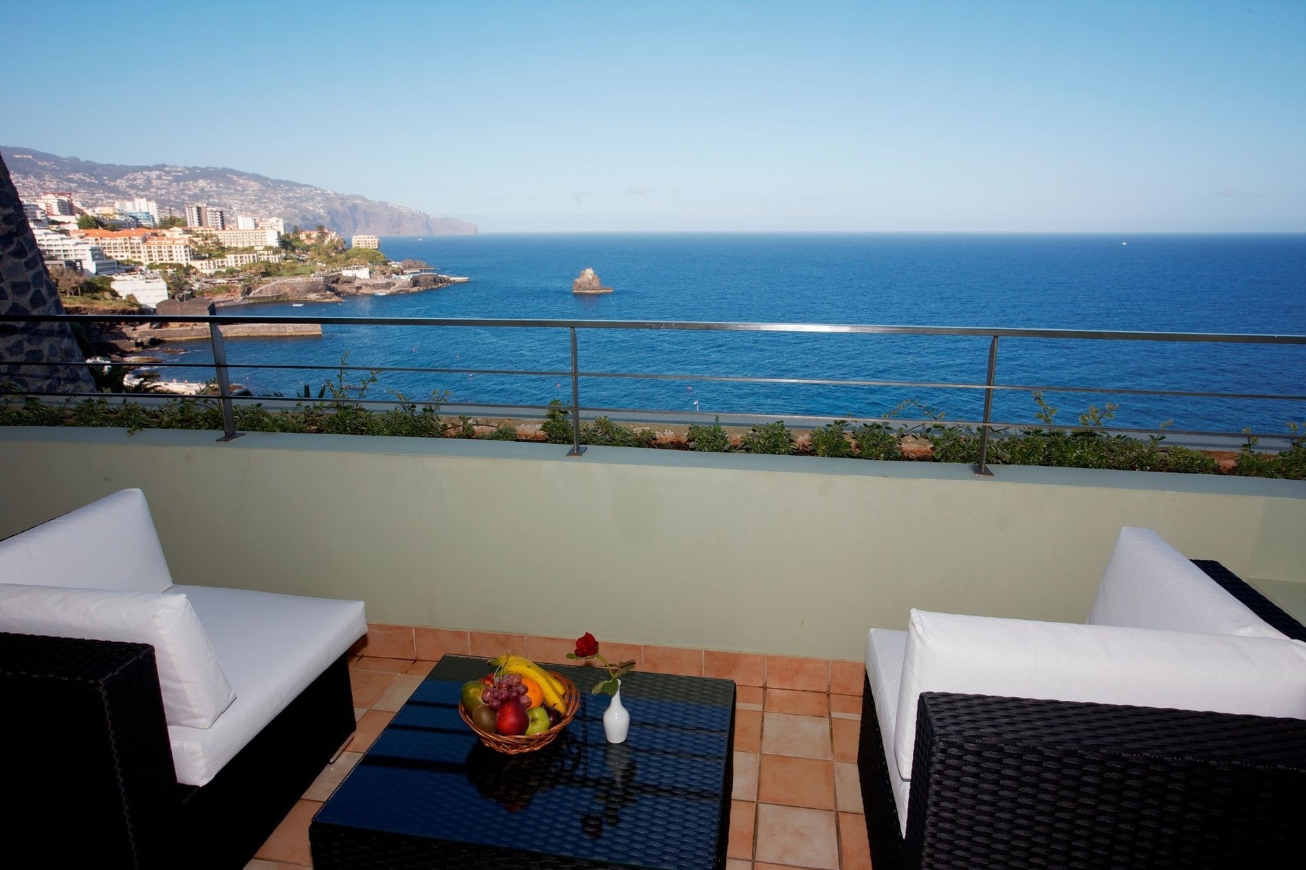 uma varanda com vista para o oceano e uma cidade