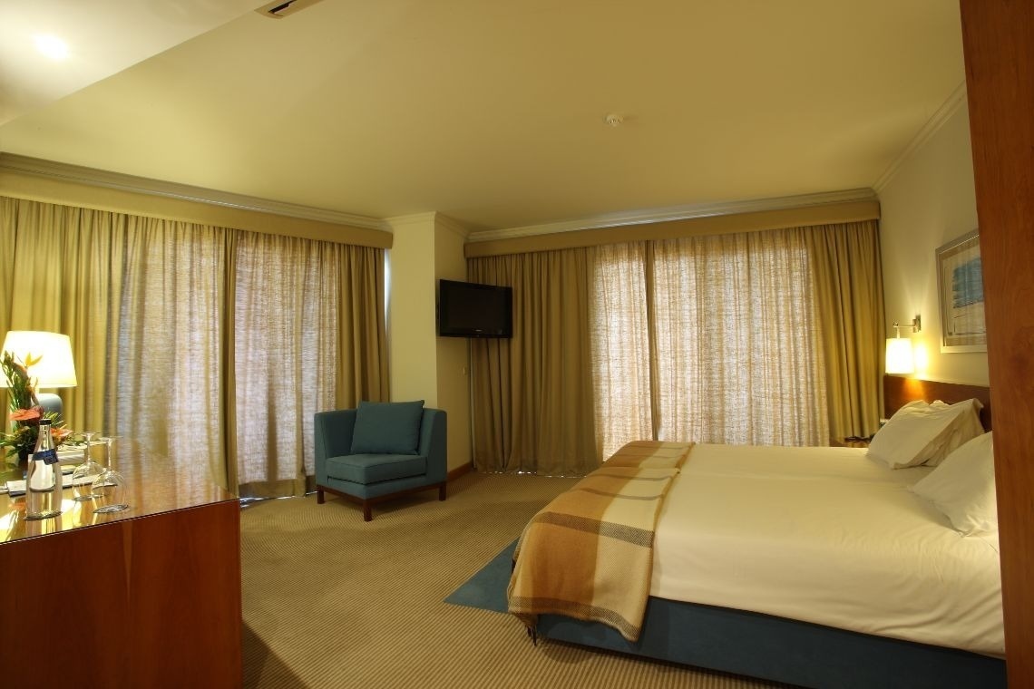 a hotel room with a bed and a chair