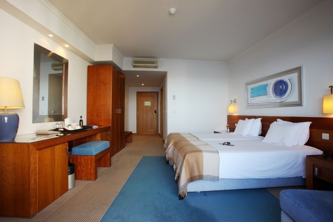 a hotel room with two beds and a blue rug