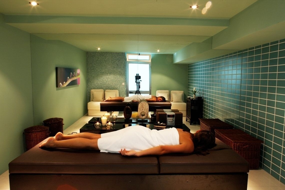 a woman in a bikini is taking a shower in a steam room .