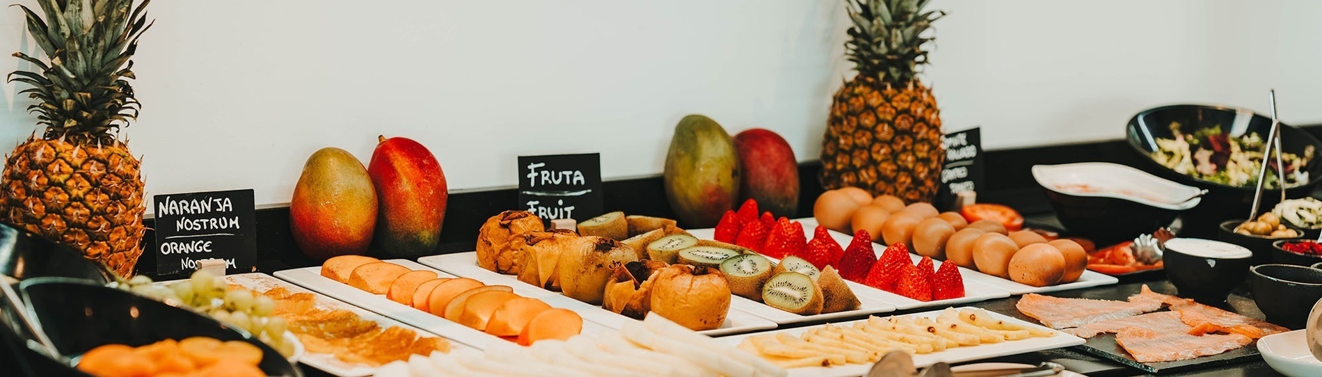 une table remplie de fruits et d' œufs avec un panneau indiquant fruta