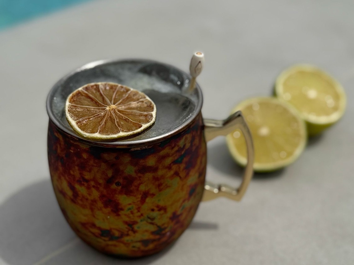 a drink in a mug with a slice of lemon on top