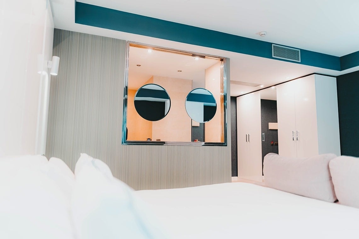 una habitación de hotel con una cama , una silla , una televisión y una ventana .