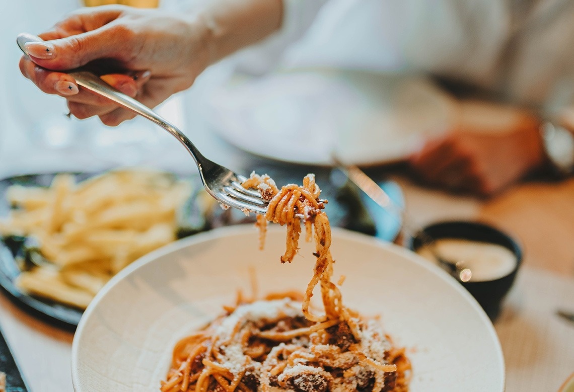 a person is eating spaghetti with a fork