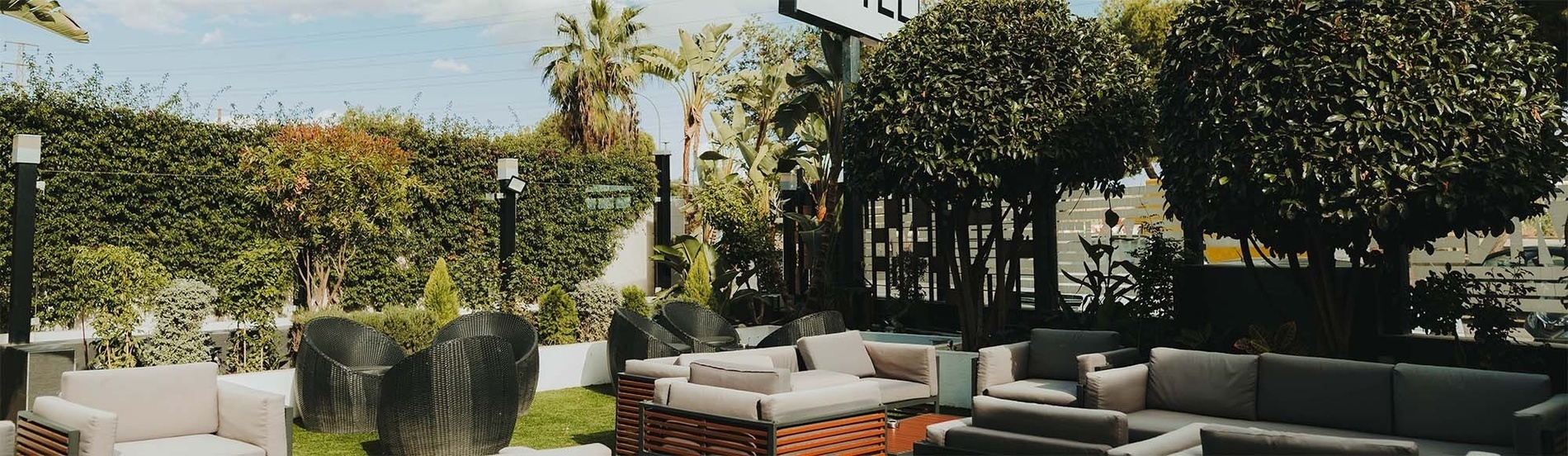 un patio avec des canapés et des chaises à côté d' un bâtiment