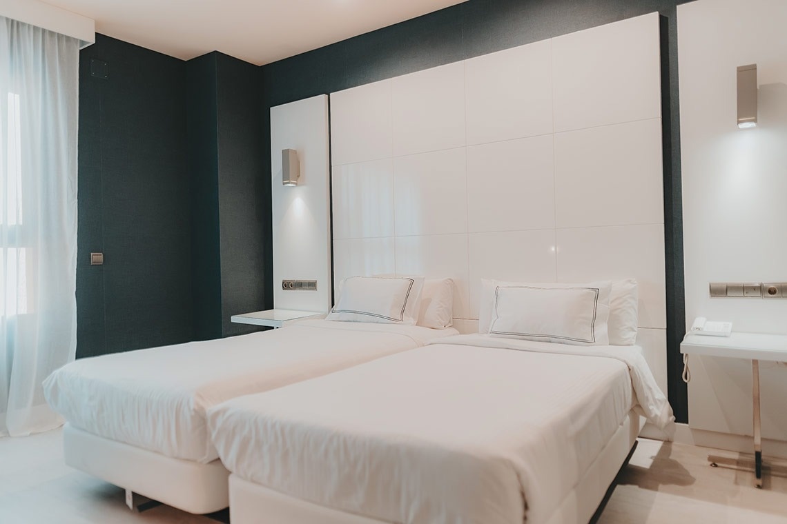 une chambre d' hôtel avec deux lits et un lavabo