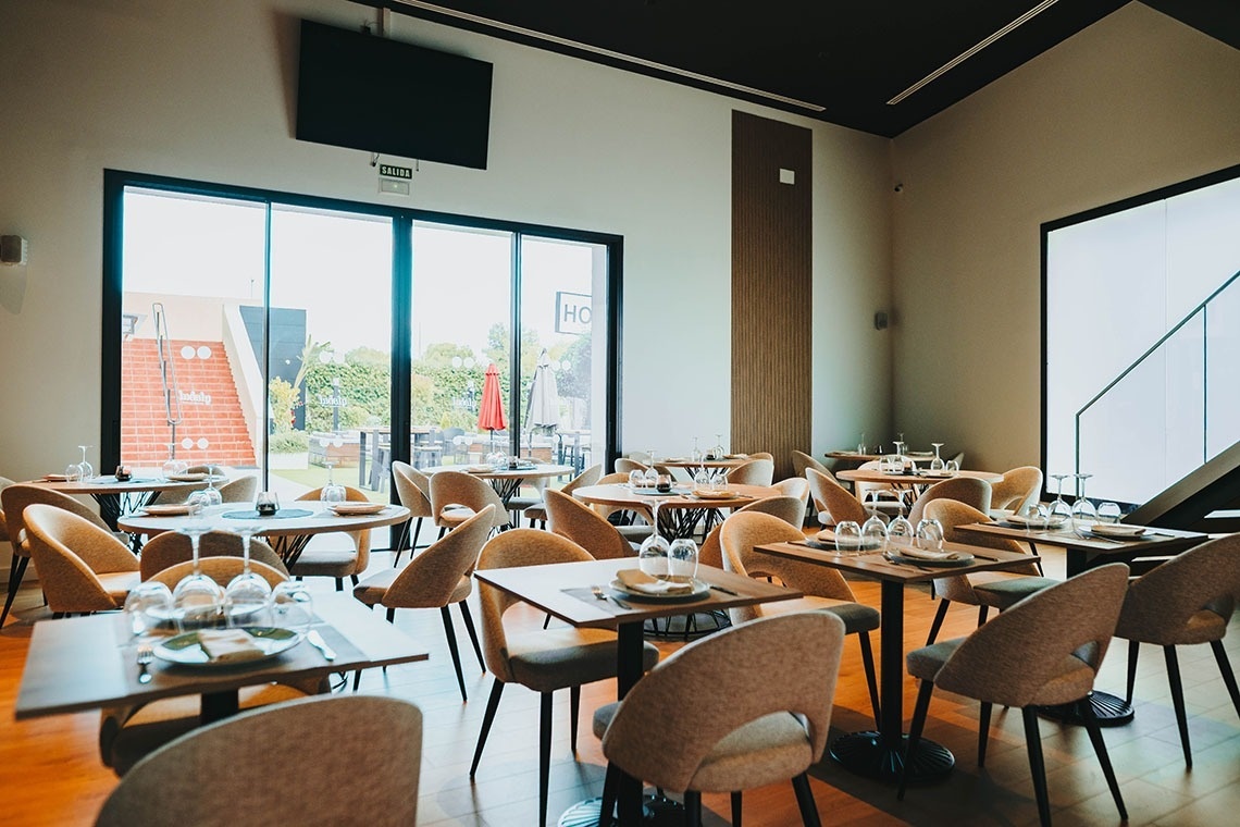 une salle à manger avec des tables et des chaises et une télévision au plafond