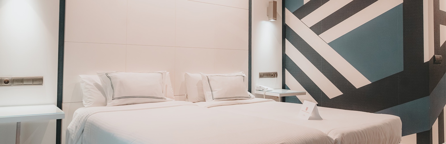 une chambre d' hôtel avec un lit et des oreillers blancs