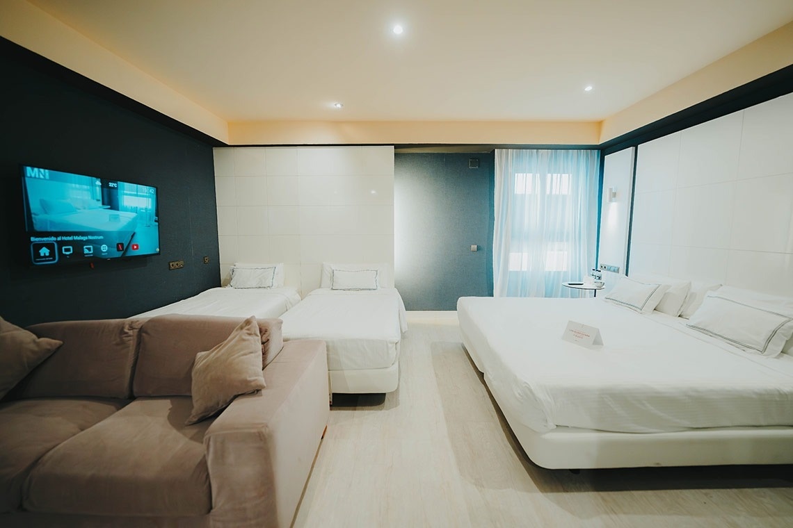 una habitación de hotel con dos camas y una televisión que muestra la página de inicio