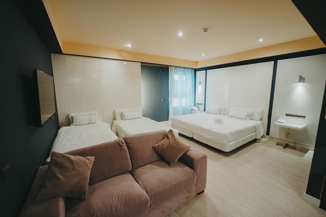 una habitación de hotel con dos camas y un sofá