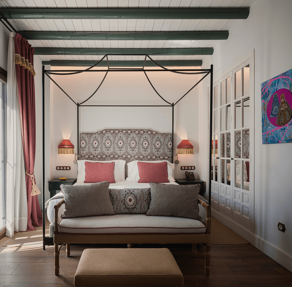un dormitorio con una cama con dosel y un sofá