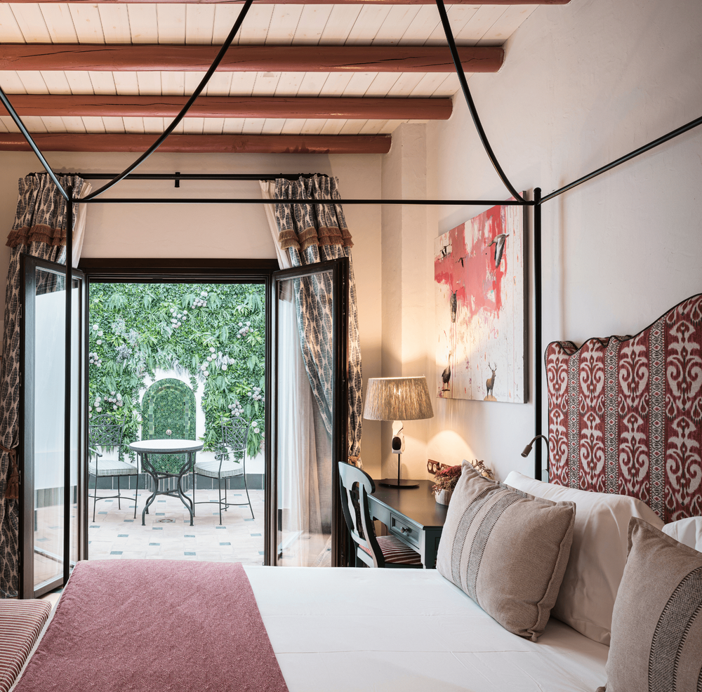 una habitación con una cama con dosel y una mesa