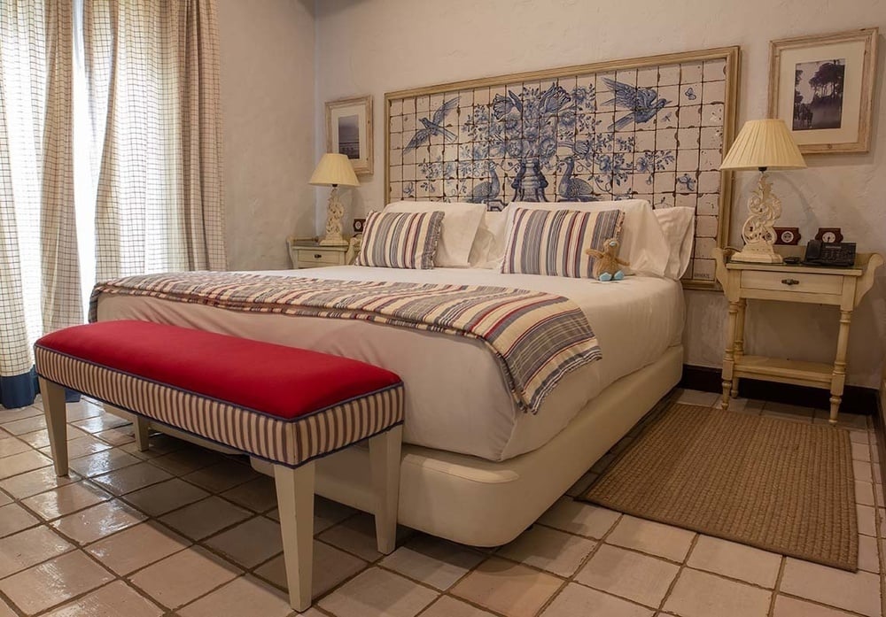 a bedroom with a blue and white tiled headboard