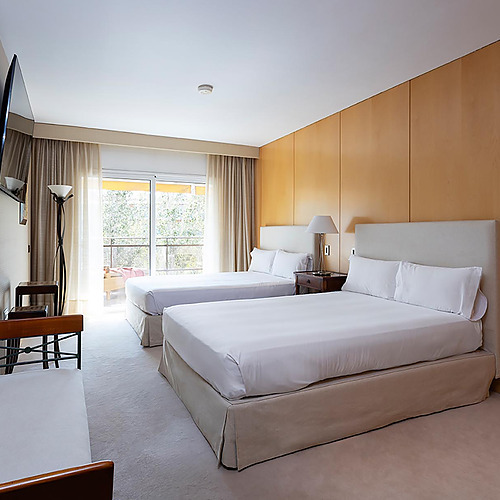 Chambre double avec deux lits, télévision et vue sur l'extérieur. Suites del Mar Fenals Apartments