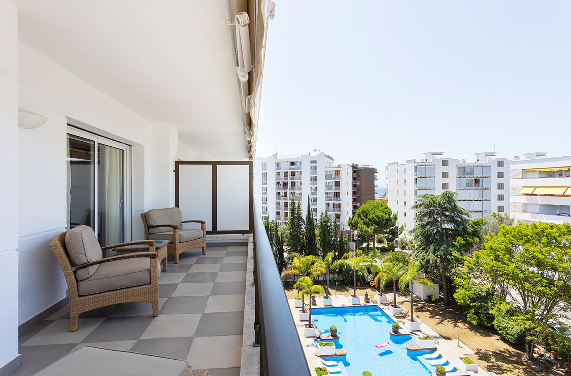 Balcón con vistas a piscina y edificios. Suites del Mar Fenals Apartments ideal para vacaciones.