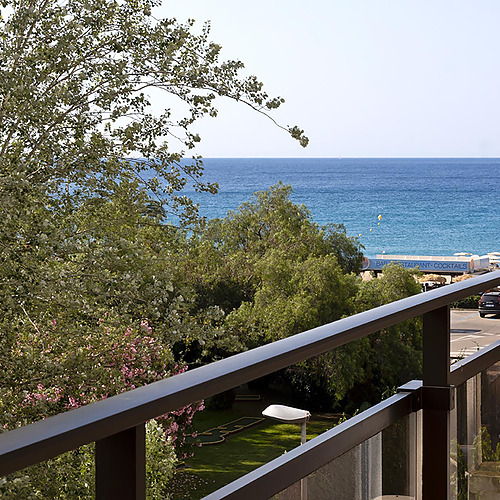 Vue sur la mer depuis le balcon avec Suites del Mar Fenals Apartments, arbres et plage.