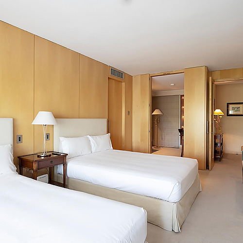 Chambre d'hôtel avec deux lits simples, décoration en bois et Suites del Mar Fenals Apartments.
