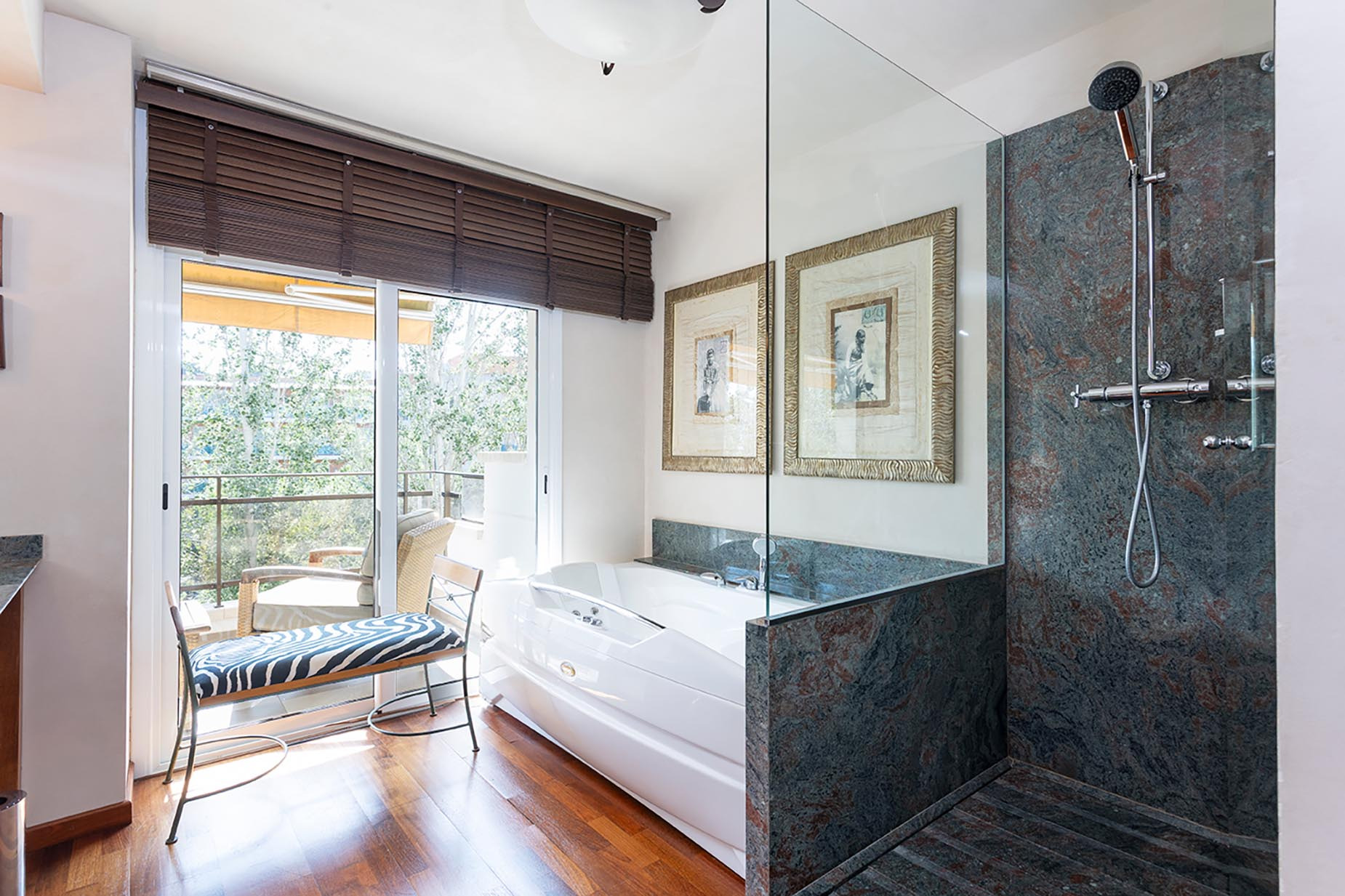 Luxury bathroom with bathtub and shower, balcony view. Suites del Mar Fenals Apartments