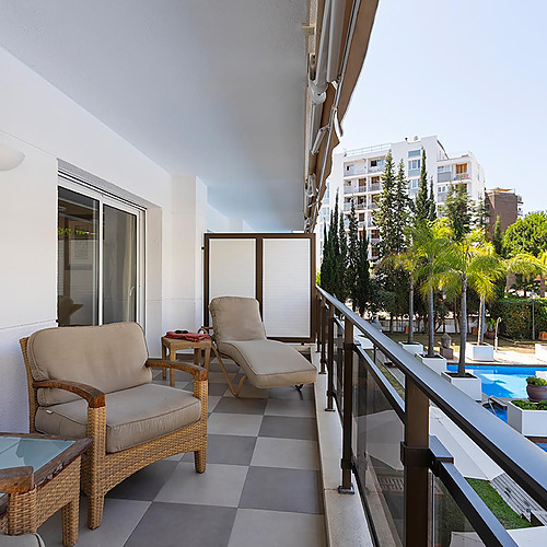 Terrasse avec vue sur la piscine et les bâtiments, idéale pour vos Suites del Mar Fenals Apartments.