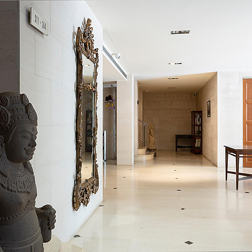 Statuette asiatique et miroir ornemental au Suites del Mar Fenals Apartments.