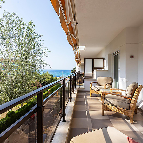 Balcon avec vue sur la mer et fauteuils en rotin, idéal pour les Suites del Mar Fenals Apartments.