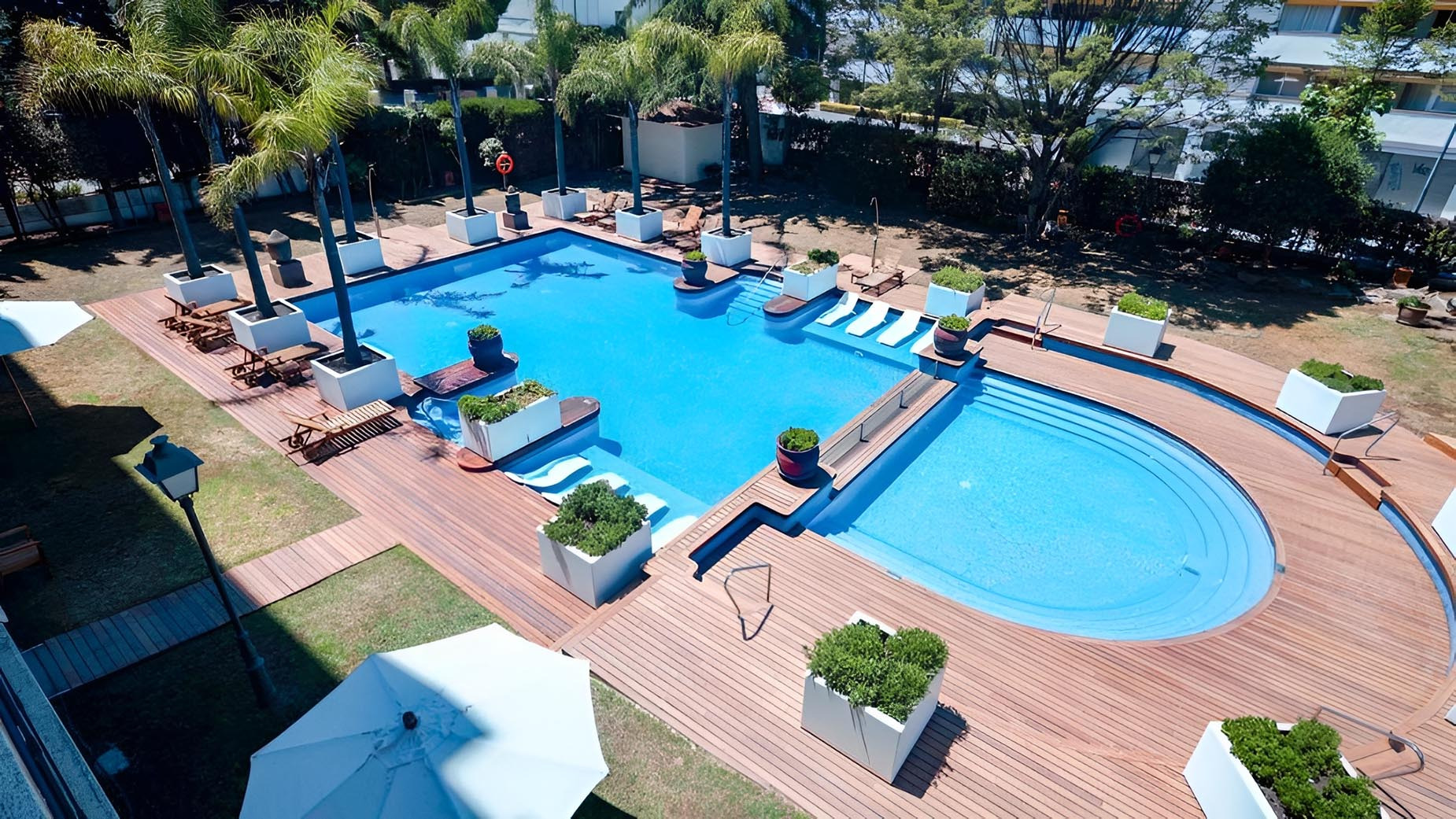 Atardecer en Suites del Mar Fenals Apartments: piscina y palmeras.