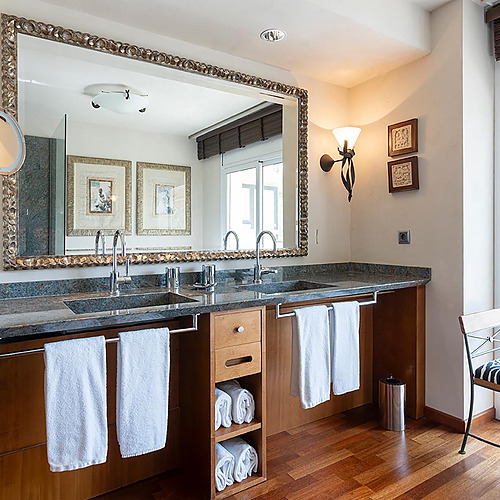 Salle de bain avec double vasque, grand miroir, serviettes blanches et Suites del Mar Fenals Apartments.