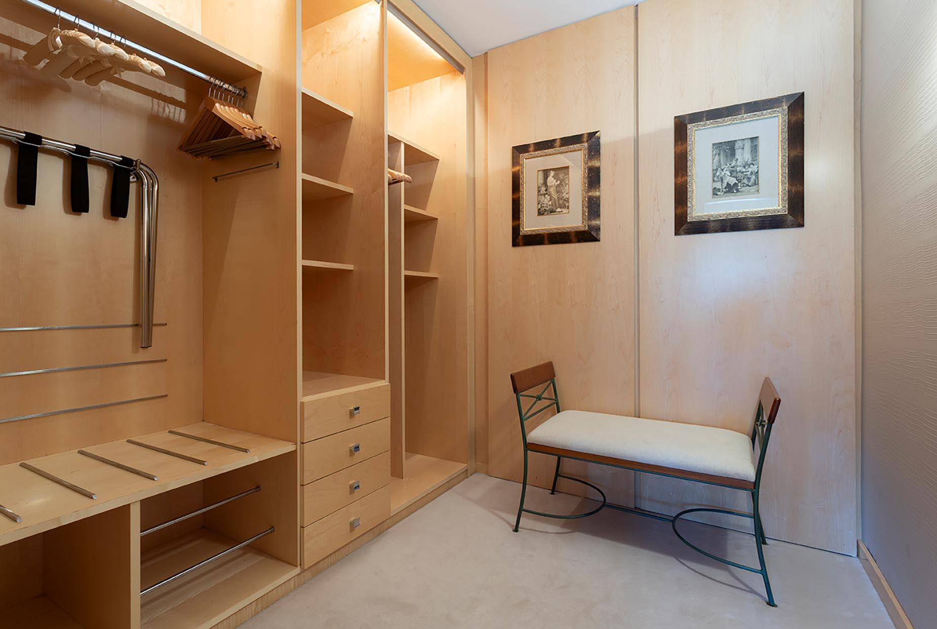 Spacious walk-in closet with ample shelving, hanging space, and seating, perfect for Suites del Mar Fenals Apartments.