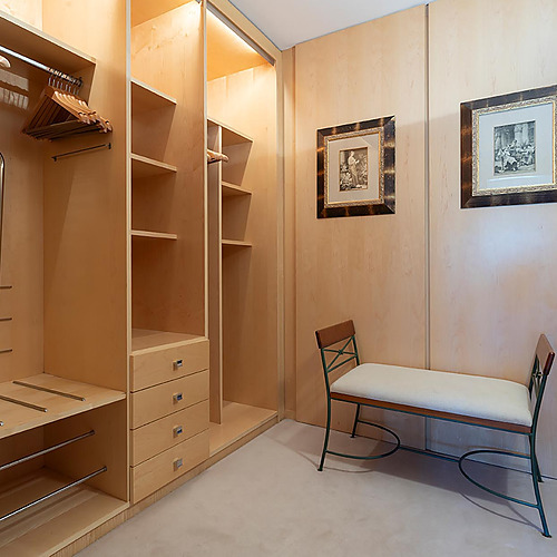 Vestiaire en bois clair avec banc et tableaux. Suites del Mar Fenals Apartments