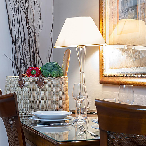 Élégante table de salle à manger avec lampe, panier de légumes et Suites del Mar Fenals Apartments.