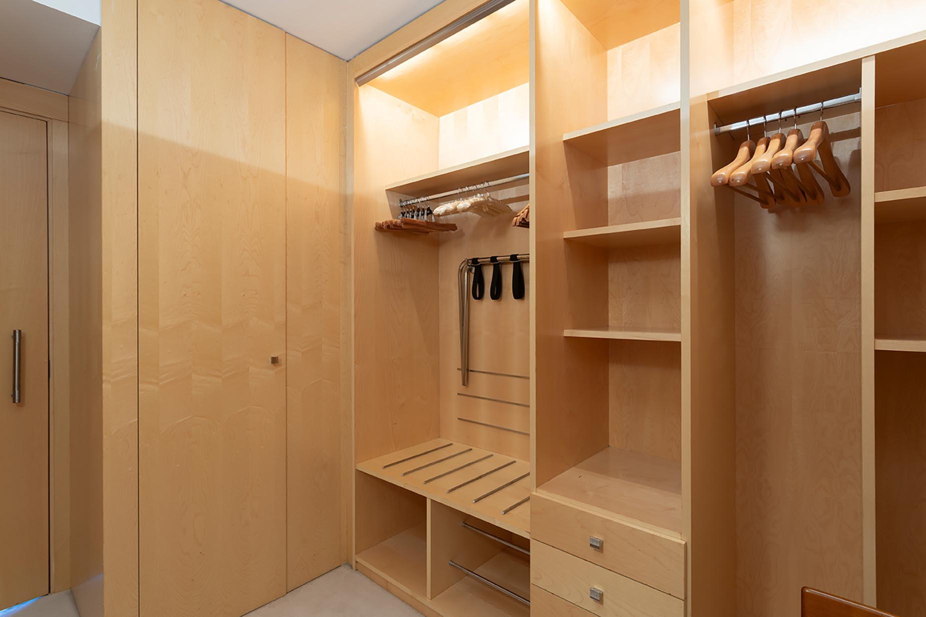 Modern built-in closet with hanging space, shelves, and drawers, ideal for Suites del Mar Fenals Apartments storage.