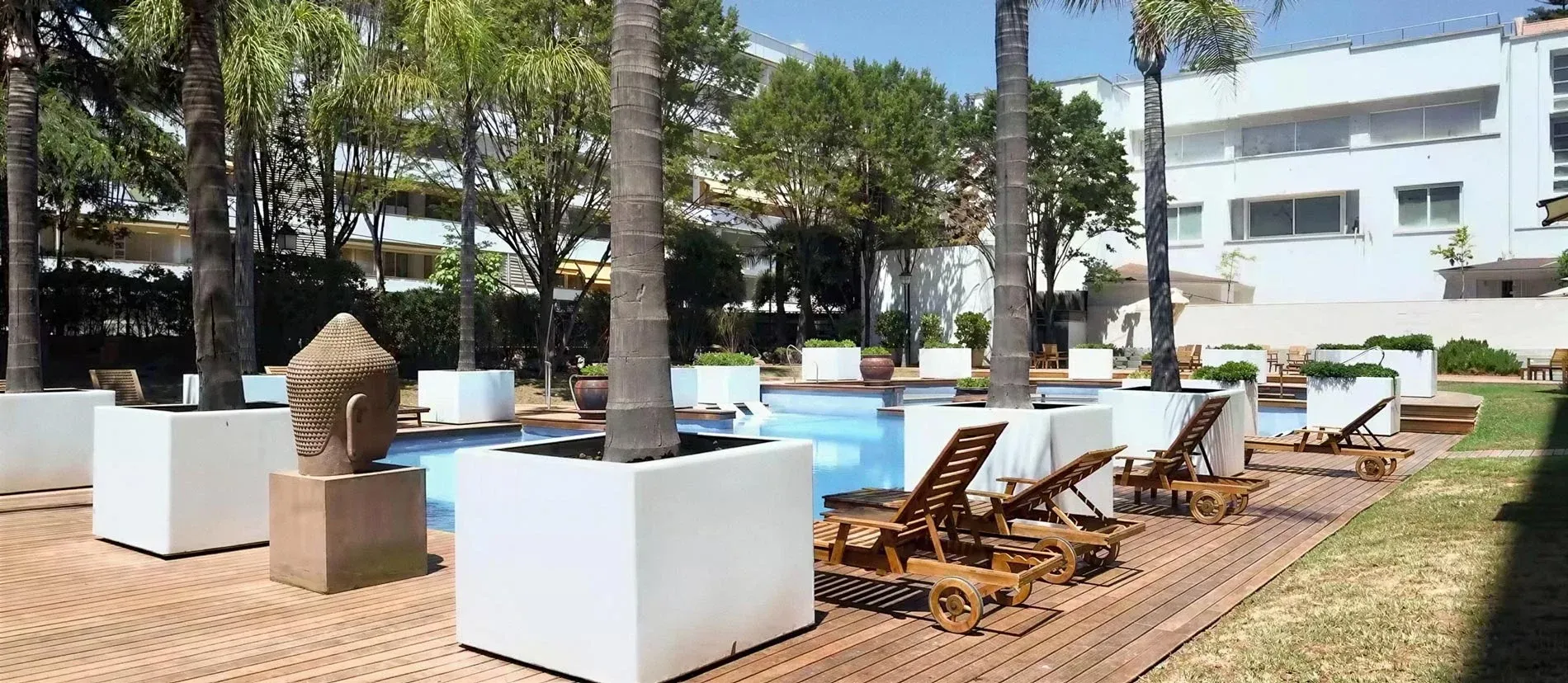Piscina exterior y jardín en Suites del Mar Fenals Apartments.