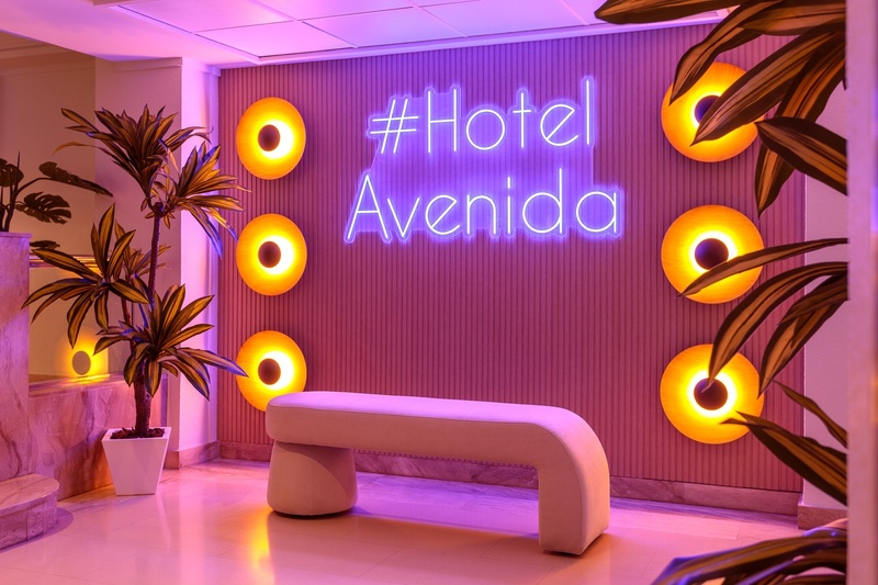 un banco frente a una pared que dice hotel avenida