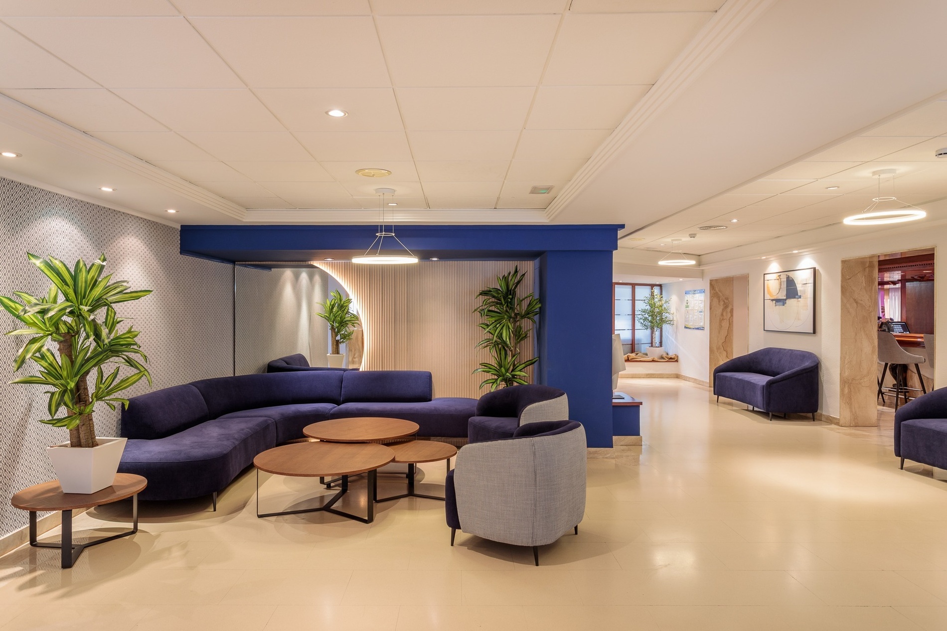 una sala de estar con un sofá azul y sillas