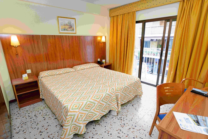 una habitación de hotel con una cama y una mesa