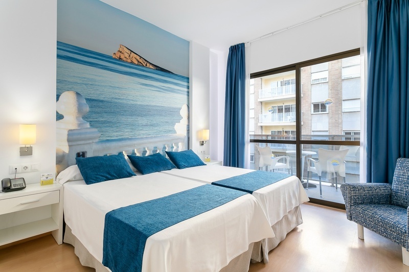 una habitación de hotel con dos camas y una silla