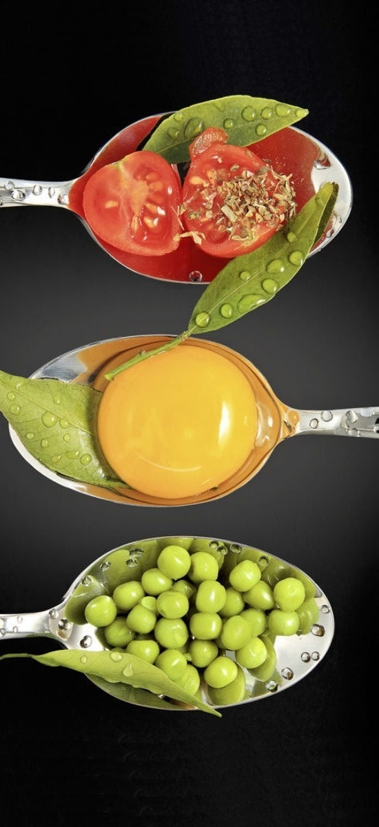 Un llarg entrepà amb salsa blanca, ceba fregida cruixent i cibulet, servit en un plat de vora blava i reflectit a la superfície brillant.