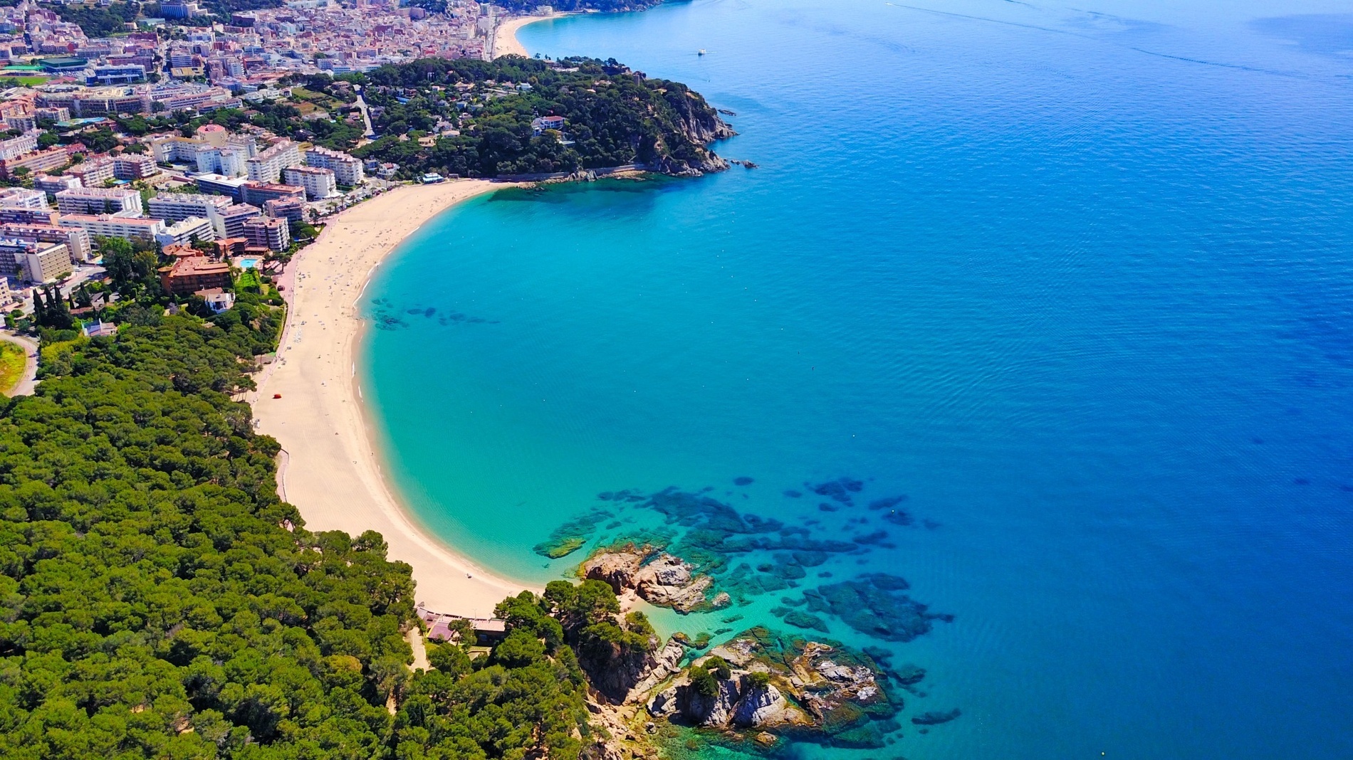 an aerial view of a beach with a city in the background