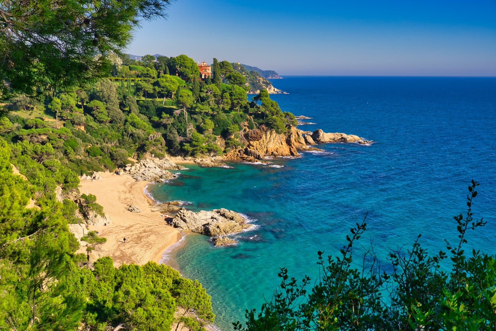 Maria del Mar Beach: Aerial hotel view with sandy beach, turquoise sea, and pine trees.