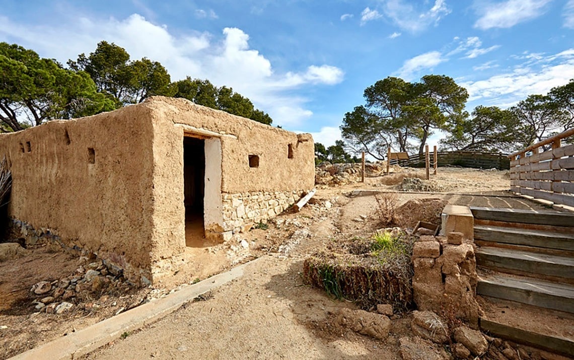 Vista aèria d'una ciutat costanera amb una platja extensa plena de gent, edificis a la vora i turons boscosos, amb nombroses embarcacions a les aigües blaves del mar.
