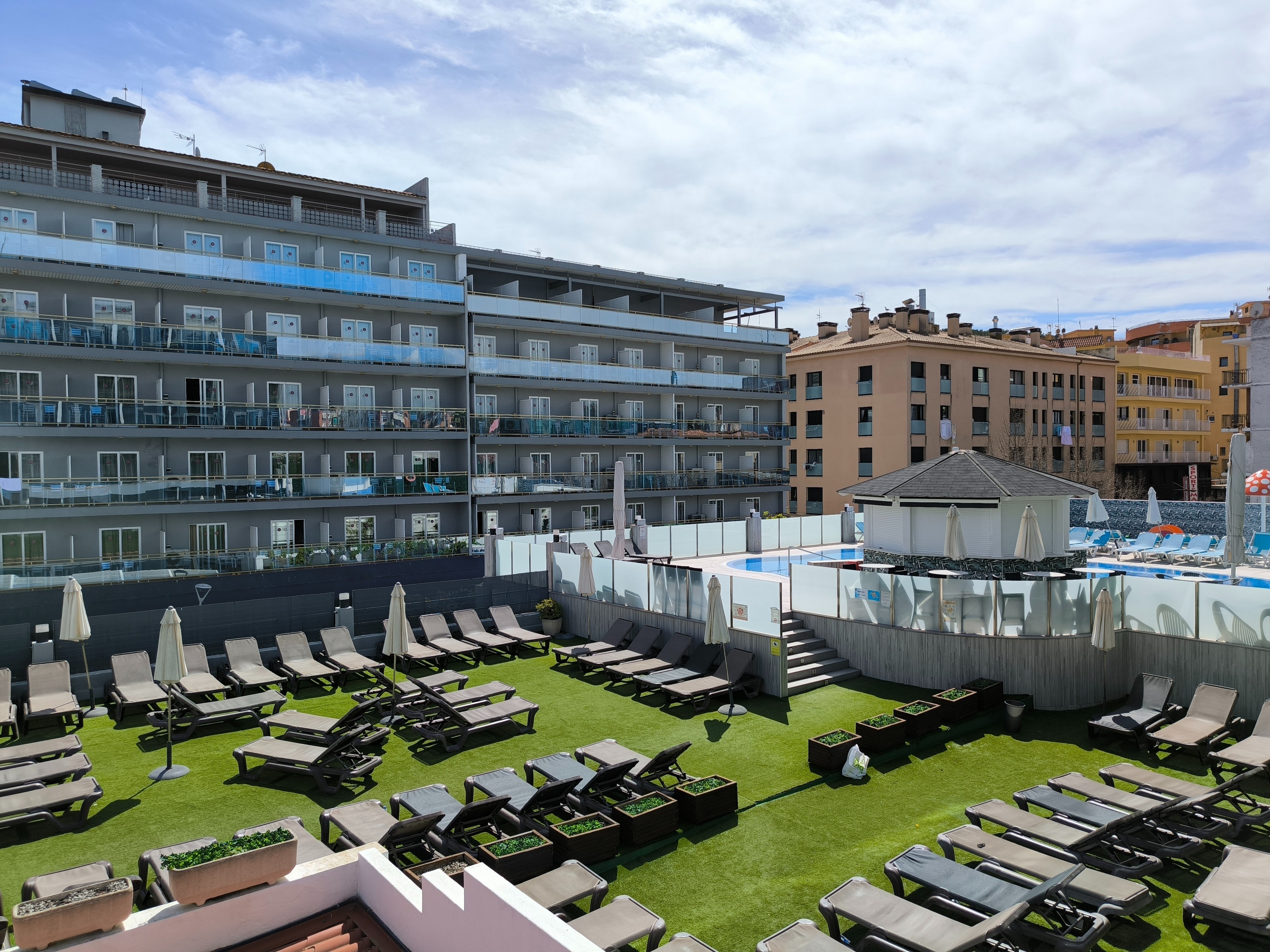 una piscina rodeada de sillas y sombrillas en un hotel