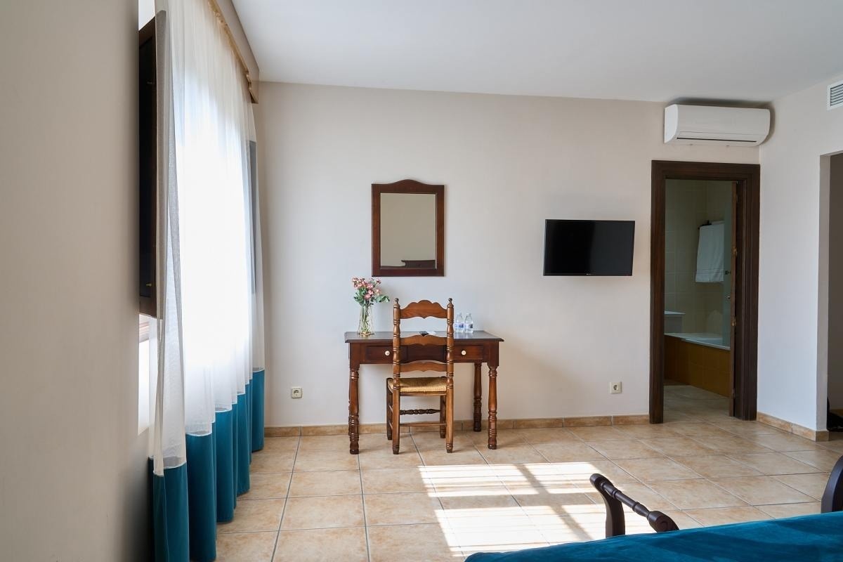 una habitación con una mesa y una silla y un televisor