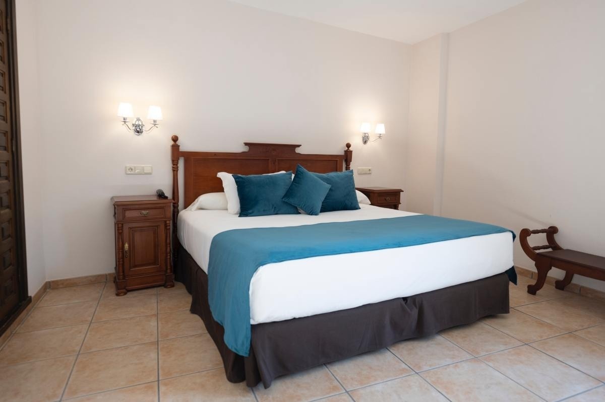 una habitación con una cama y dos mesitas de noche